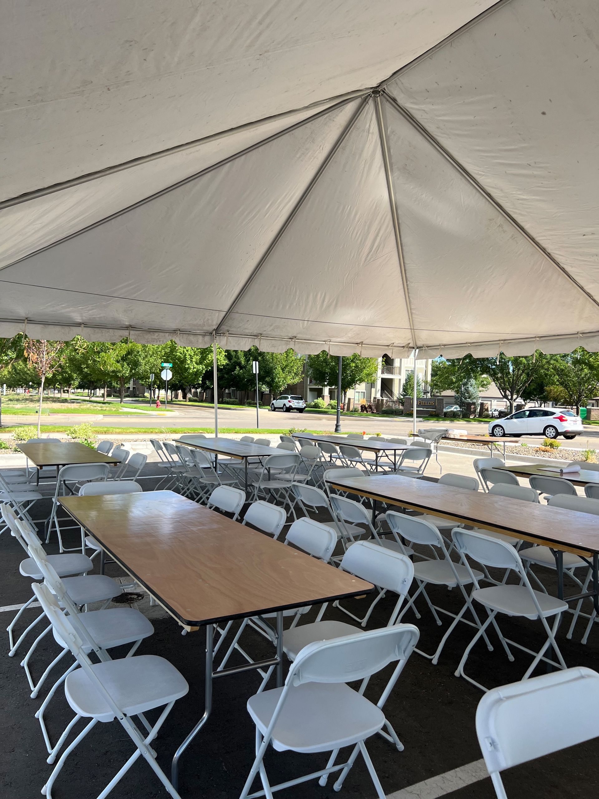 A large tent with tables and chairs underneath it.