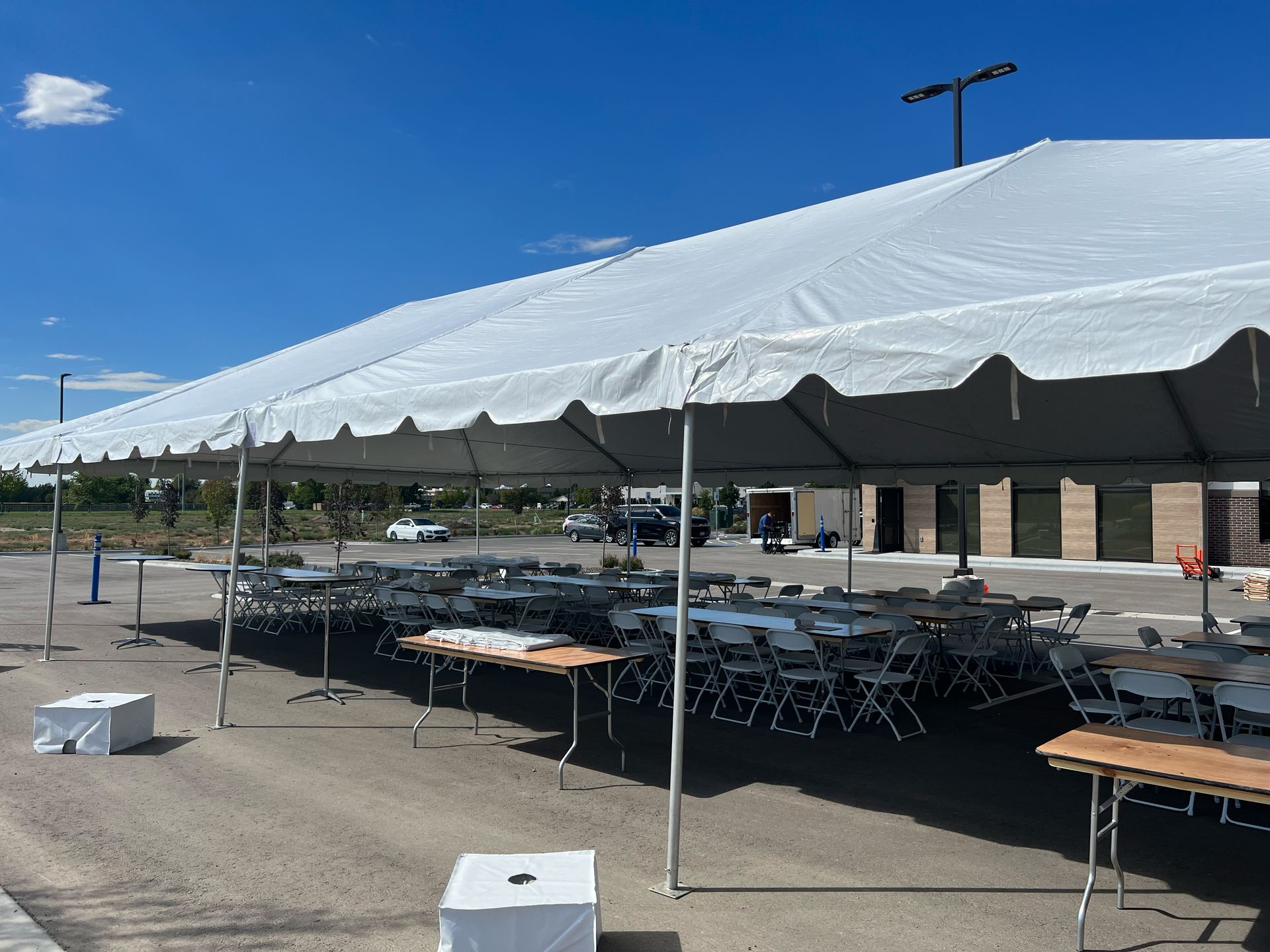 A large white tent with tables and chairs underneath it