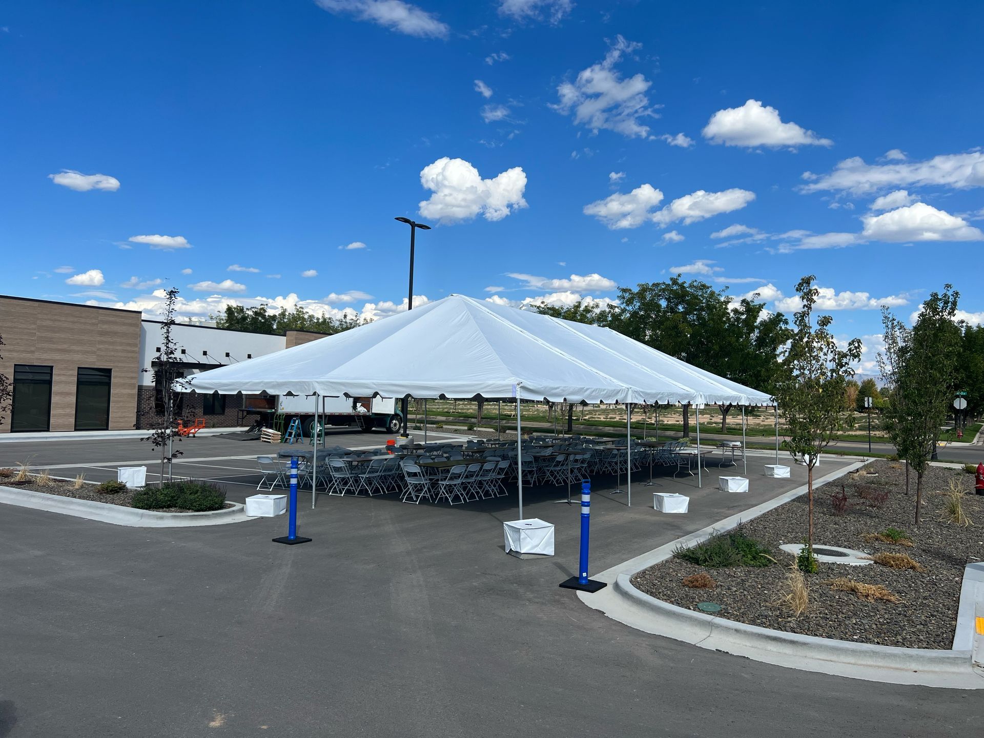 A large white tent is sitting in the middle of a parking lot.