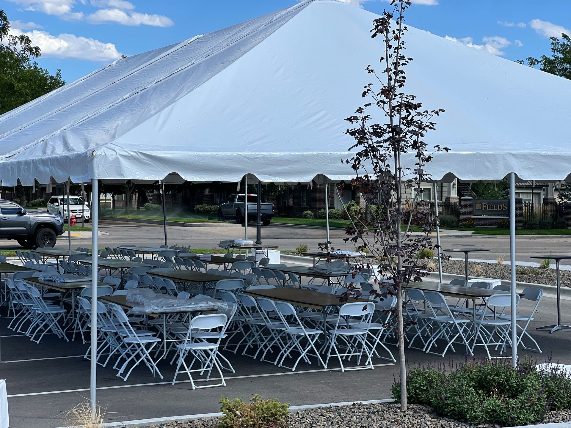 Tables and chairs under a tent in a parking lot