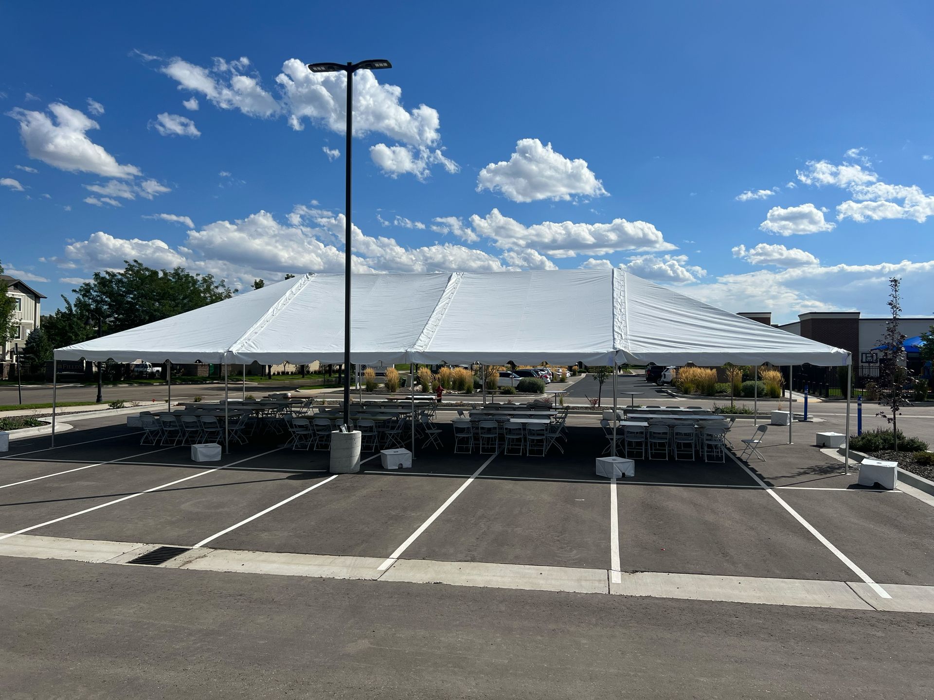 A large white tent is sitting in the middle of a parking lot.