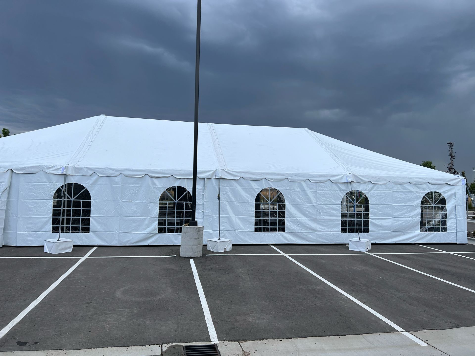 A large white tent is sitting in a parking lot.