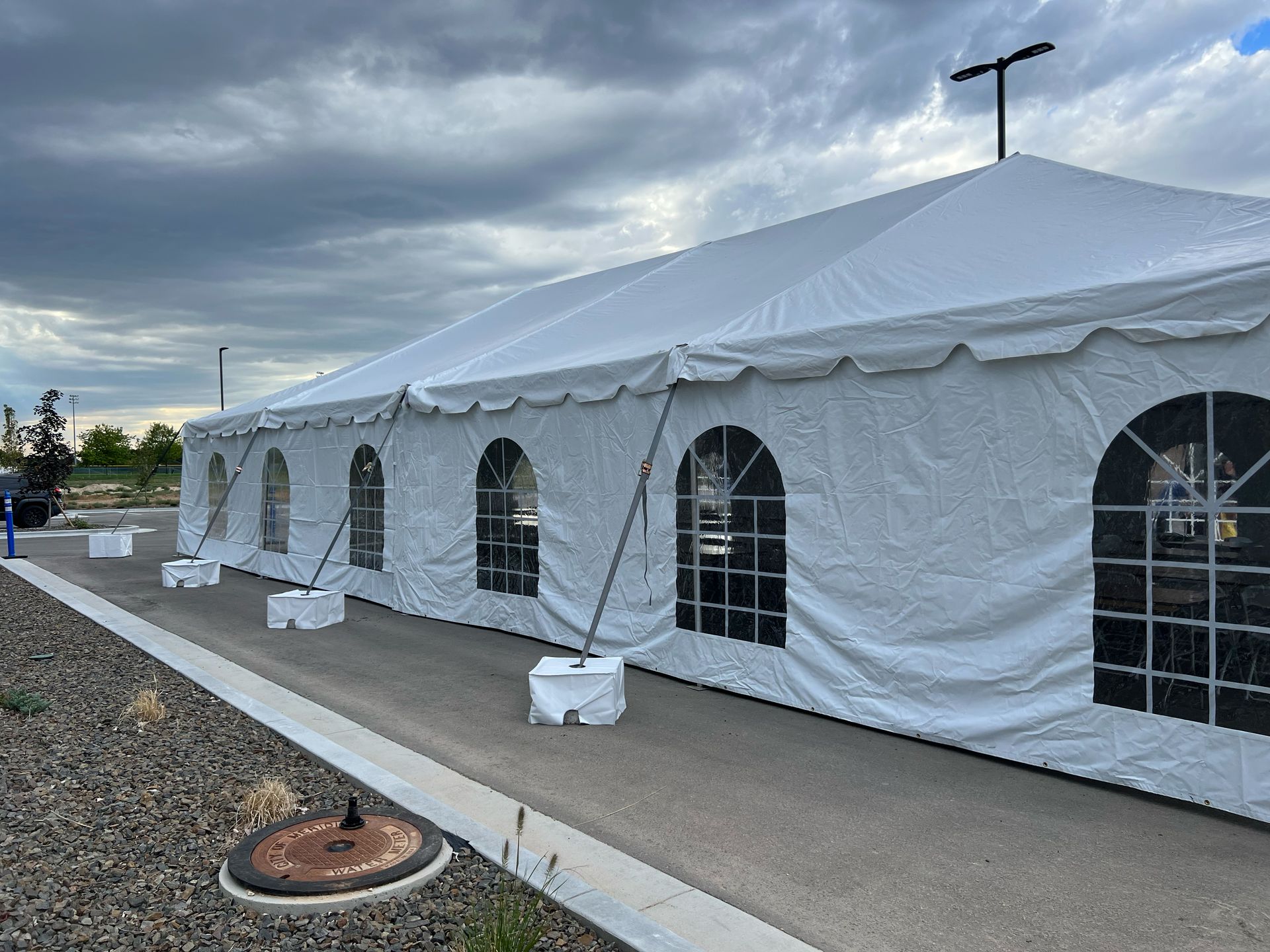 A large white tent is sitting on the side of a road.