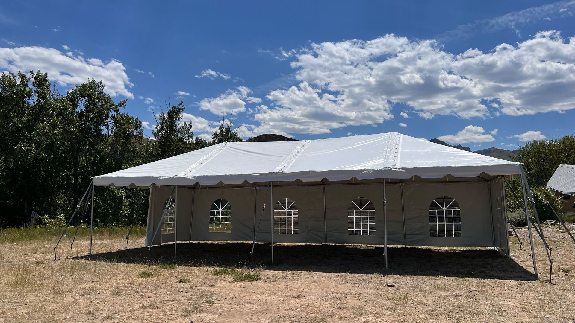 A large white tent is sitting in the middle of a field.