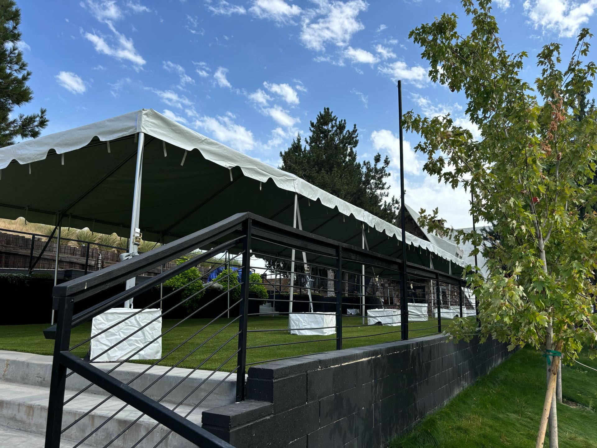 A large white tent is sitting on top of a lush green field.