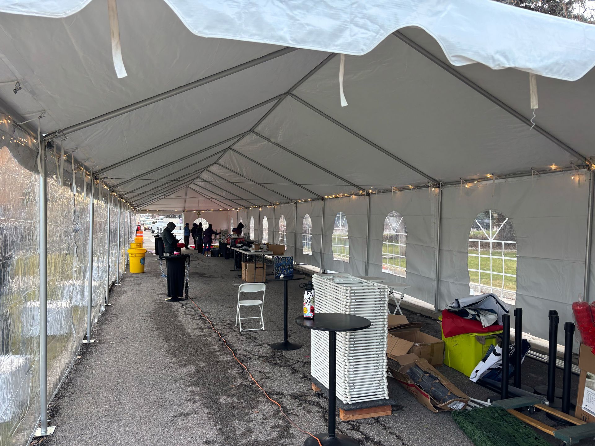 A large white tent with tables and chairs inside of it.