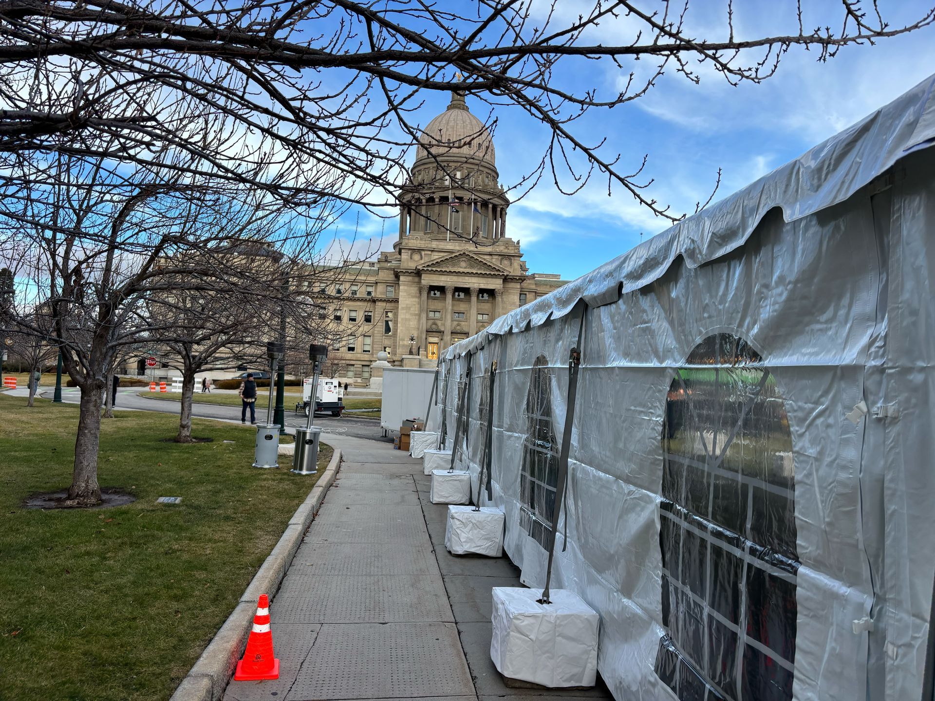 A row of tents are lined up in front of a large building.