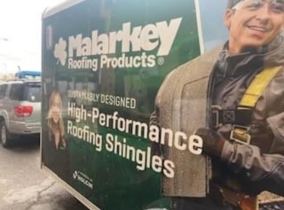 A trailer with a picture of a man on it that says malarkey roofing products