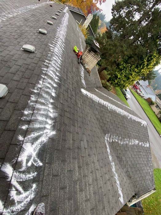 A person is working on the roof of a house.