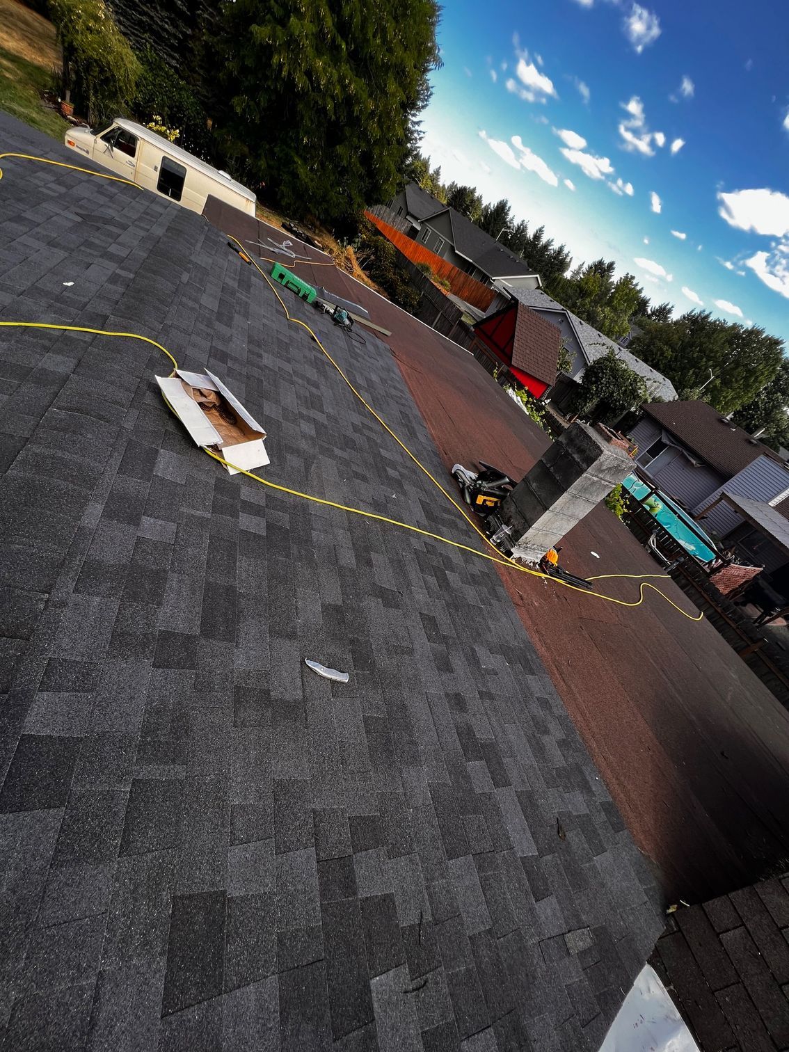 A roof with a hole in it is being repaired in a residential area.