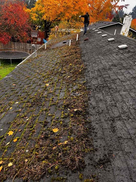 A man is standing on the roof of a house.