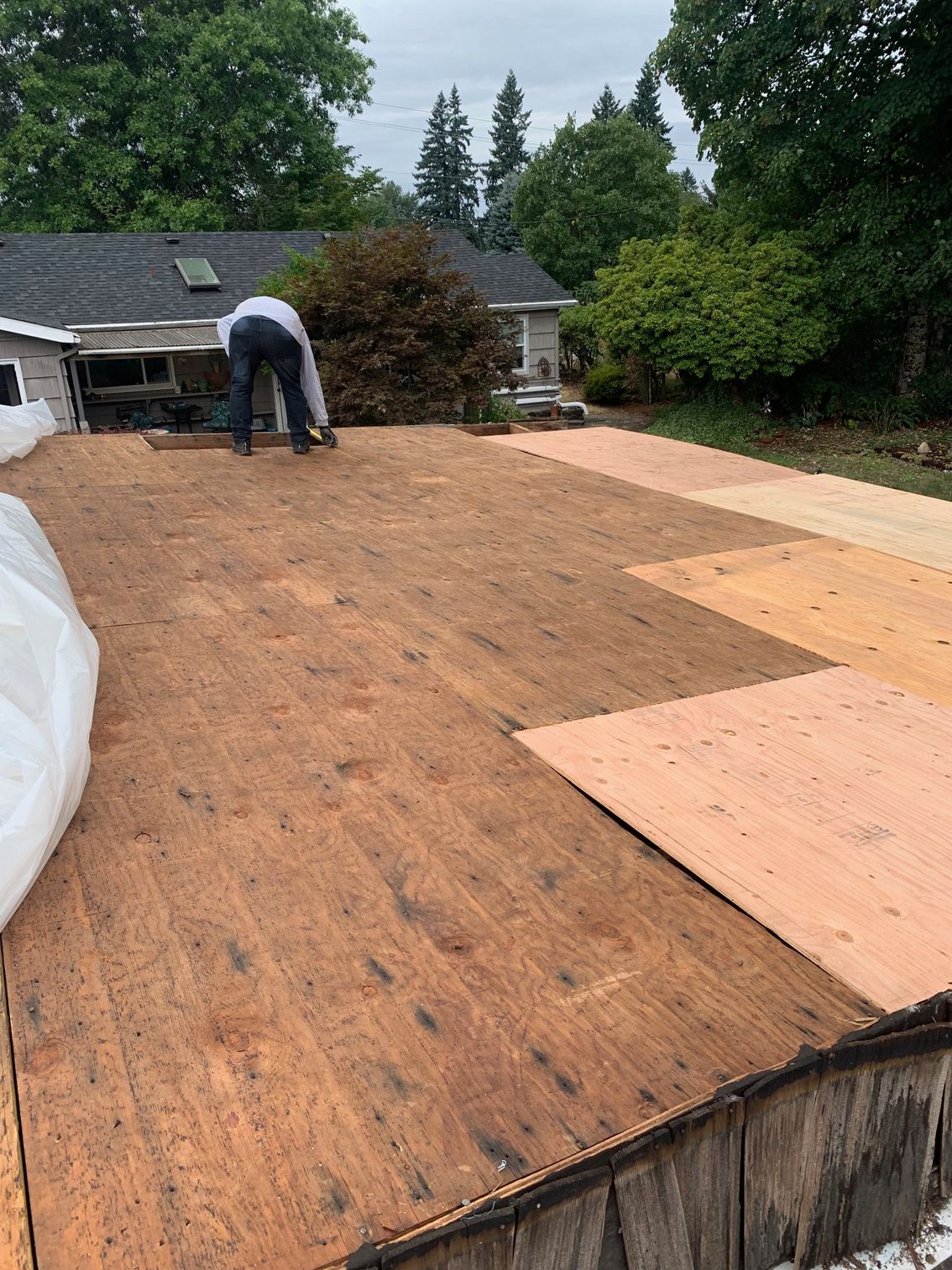 A man is working on the roof of a house.
