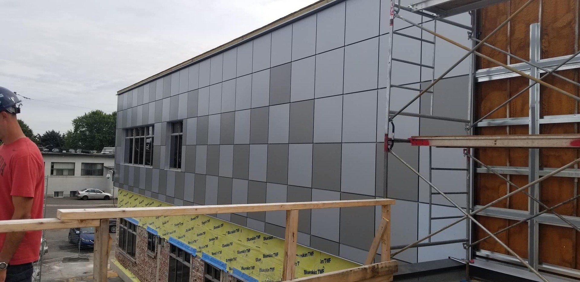 Extérieur du bâtiment en construction avec façade à motifs et échafaudage.