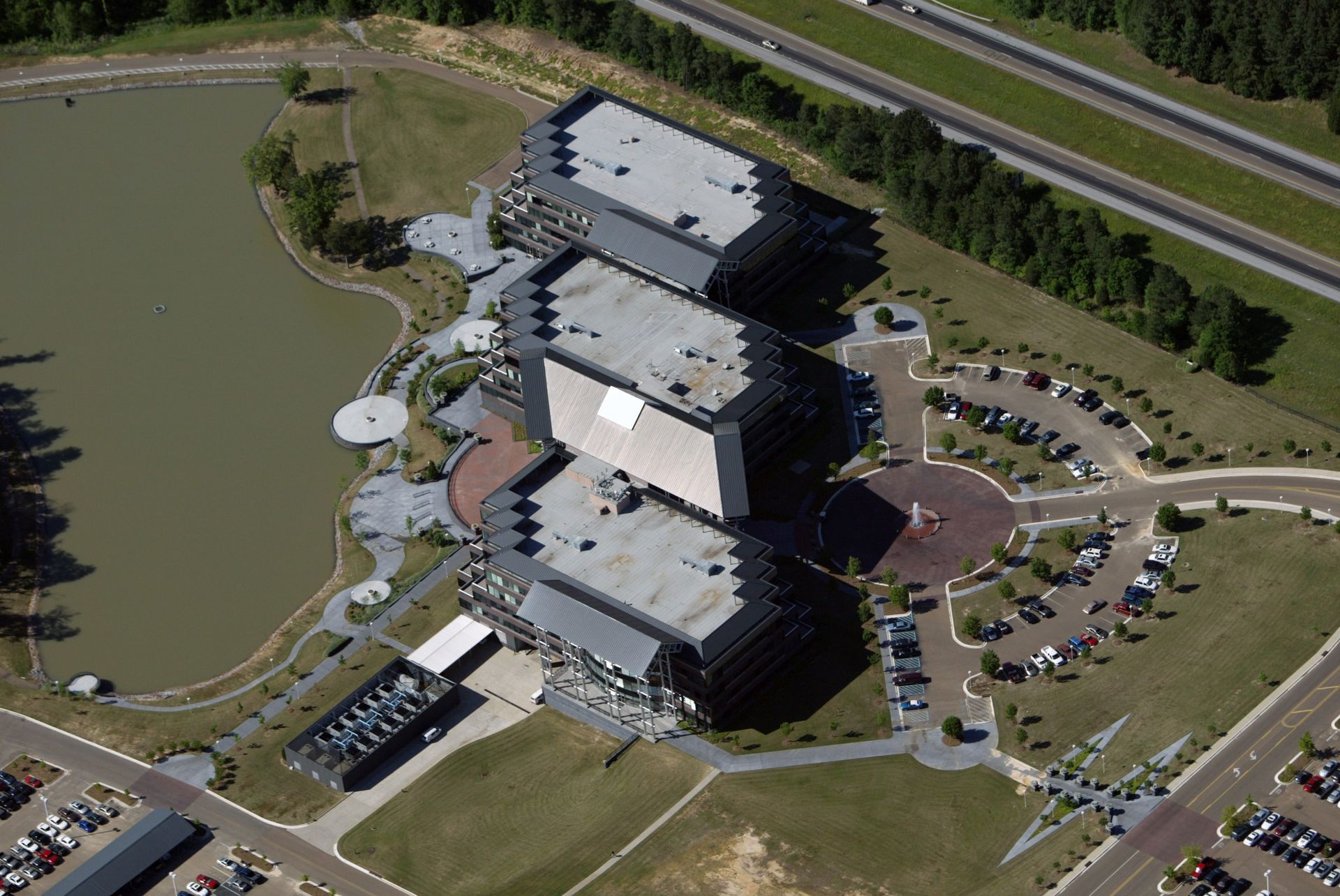An aerial view of a large building with a lake in the background