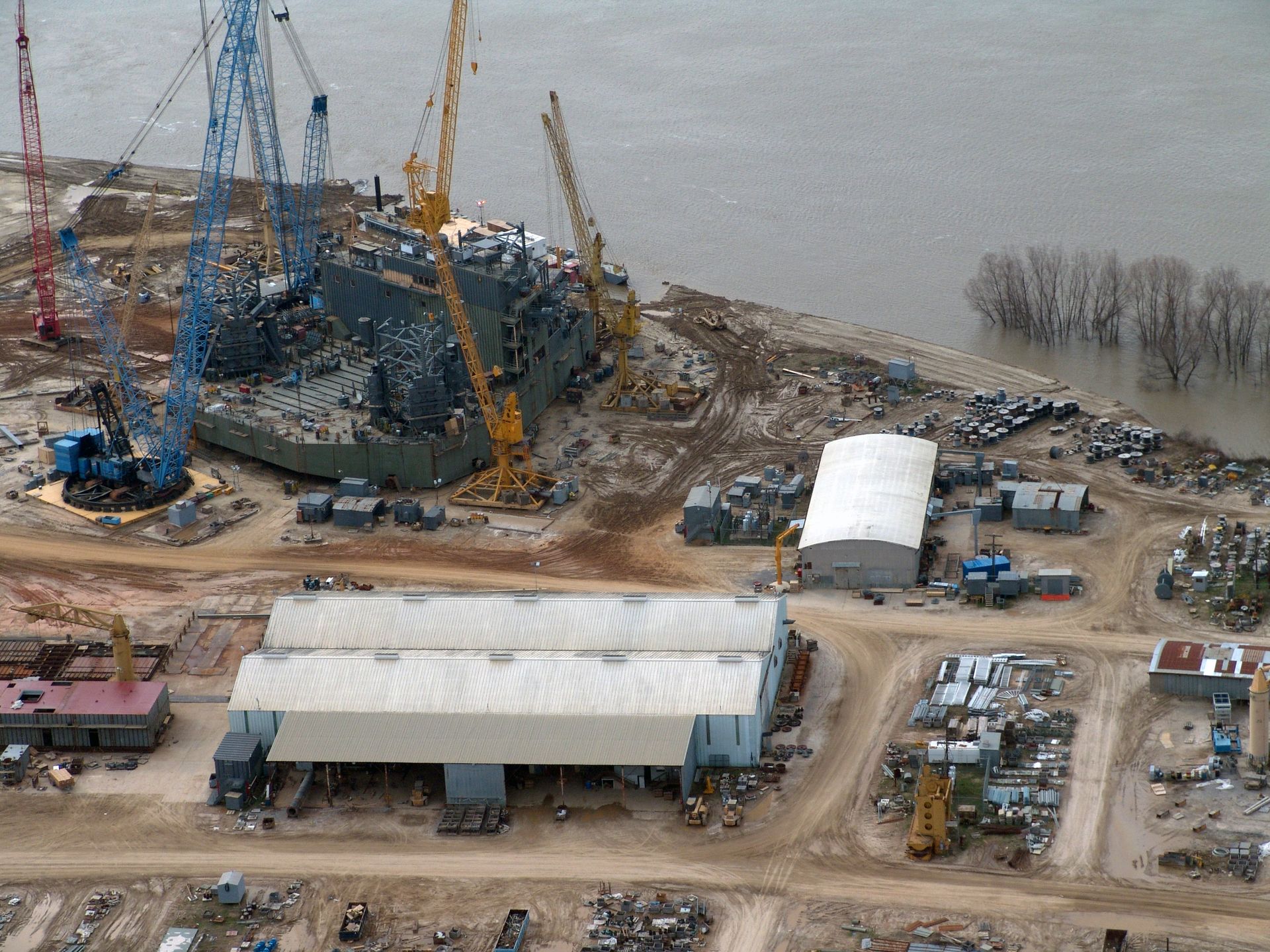 An aerial view of a construction site next to a body of water