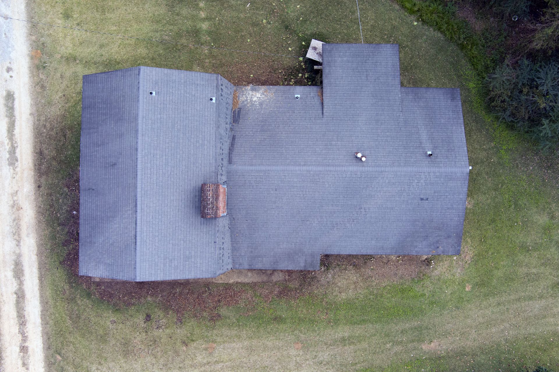 An aerial view of a house with a roof that is covered in shingles.