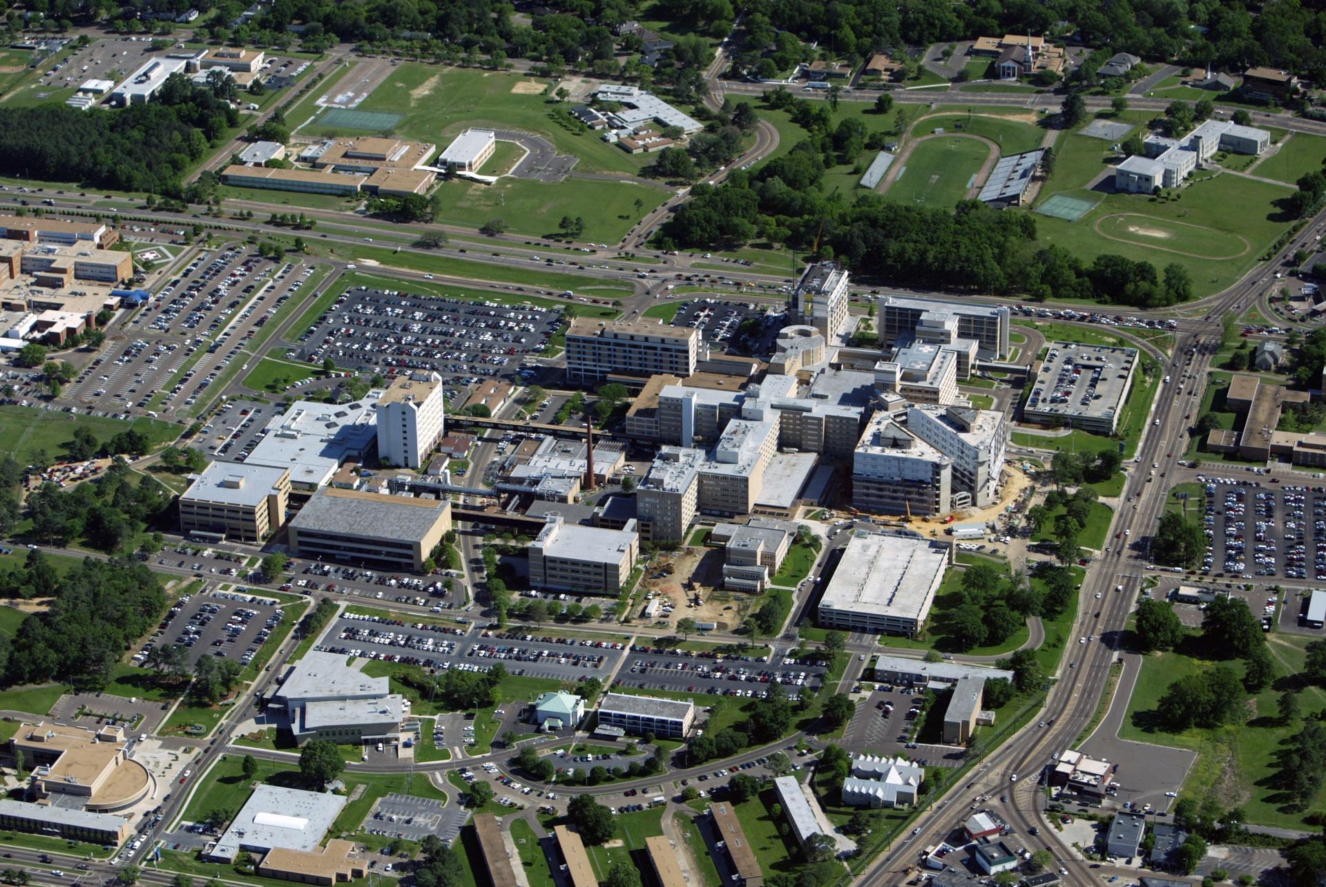 An aerial view of a large city with lots of buildings and parking lots