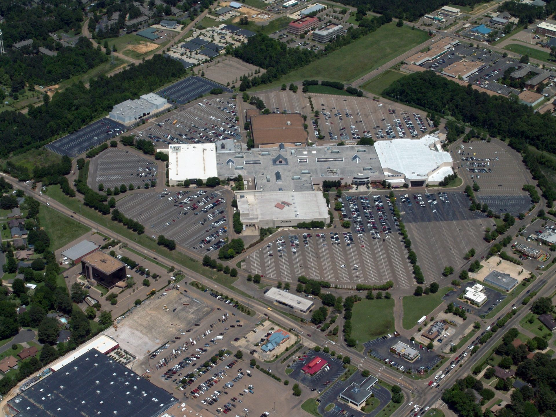 An aerial view of a large shopping mall surrounded by parking lots