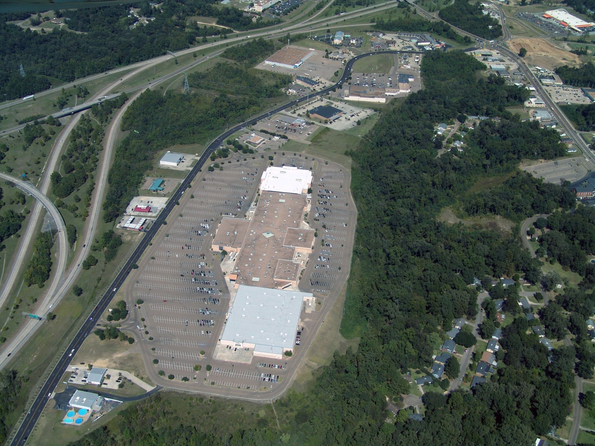 An aerial view of a shopping mall surrounded by trees