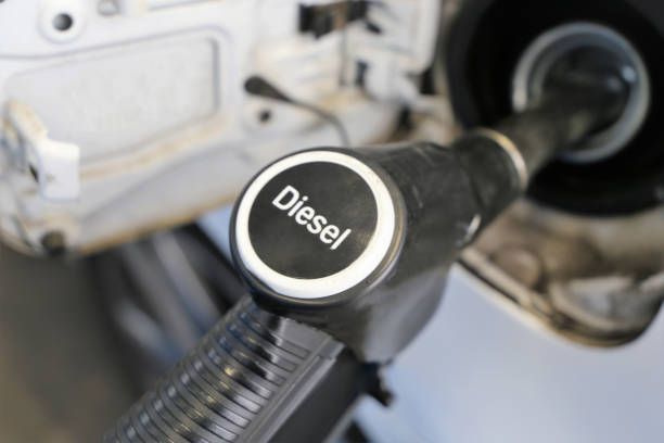 A car is being filled with diesel at a gas station