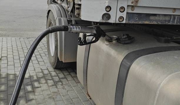 A truck is being filled with gas at a gas station.