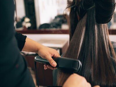 Hairstylist Straightening Girl's Hair — Hair Care in Souderton, PA