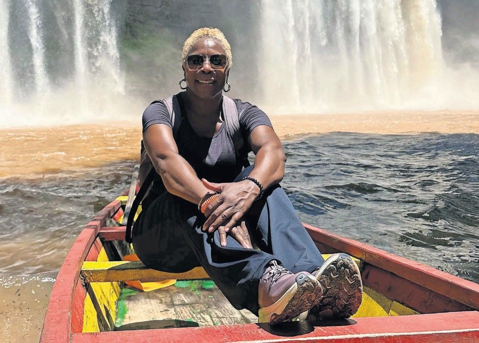 The Rev. Terrlyn Curry Avery sits in a boat next to the Botti Falls in Ghana