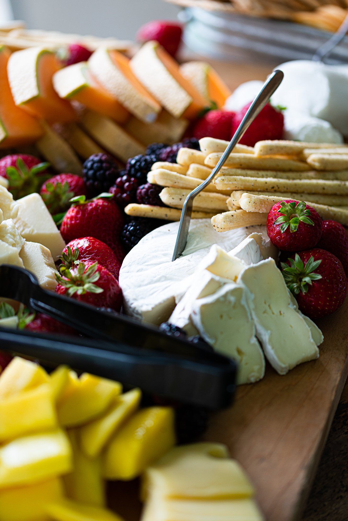 Luncheon cheeseboard with swiss, local honey, kiwis, fresh fruit preserves, aged meats, and almonds.