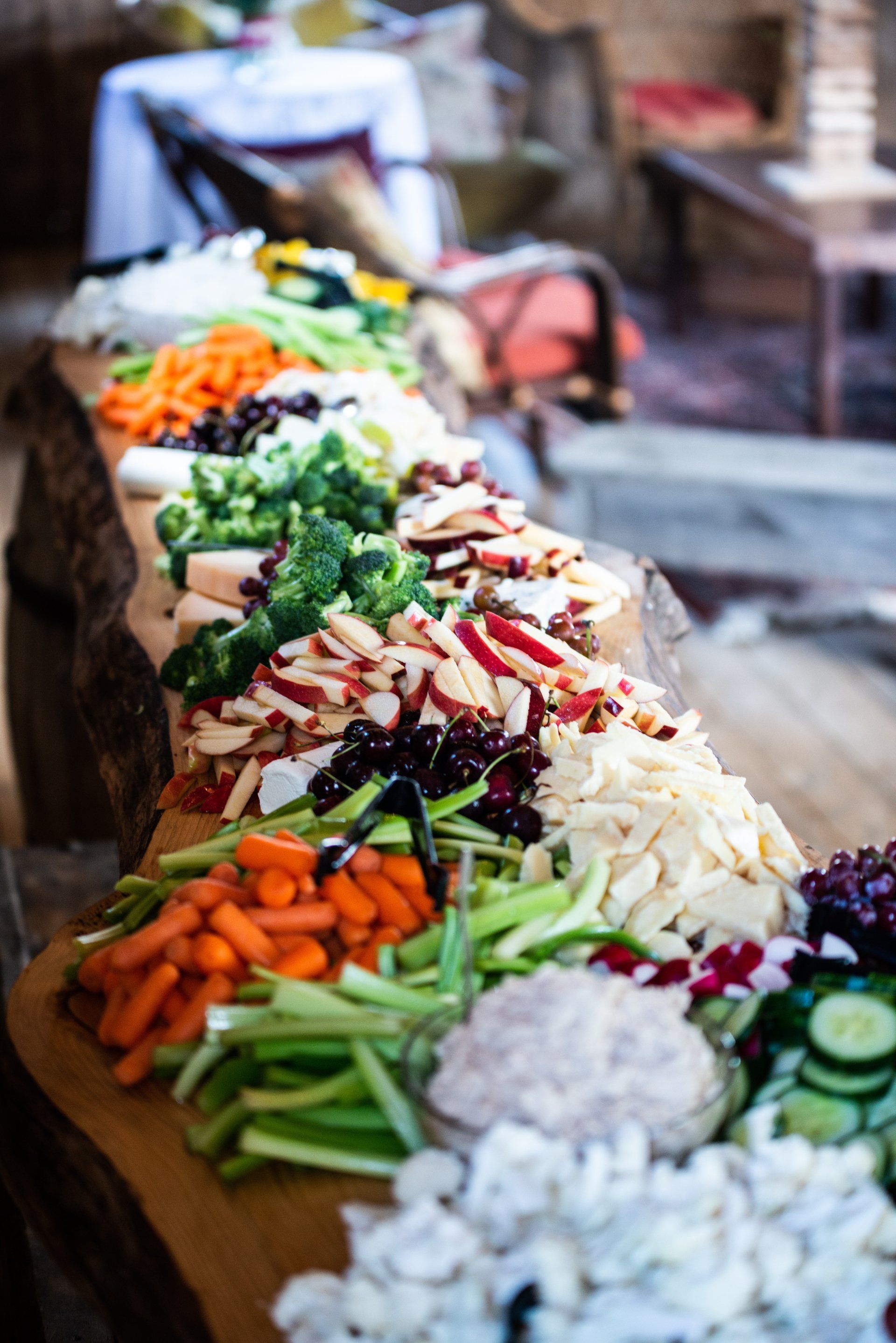 Luncheon display with aged cheeses, fresh grapes, and sliced apples.