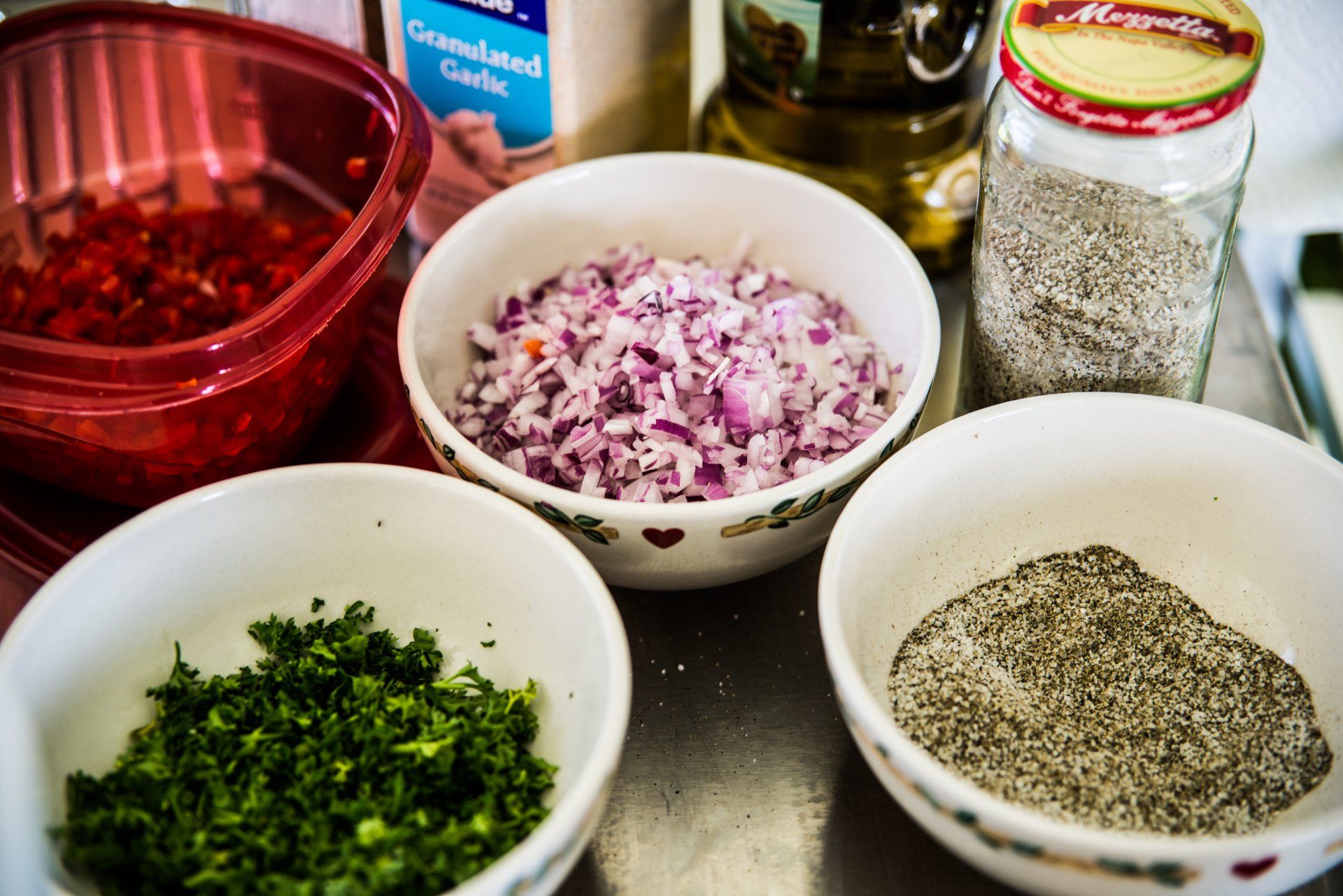 Freshly prepared catering ingredients of red onions,  cilantro, and crushed black pepper.