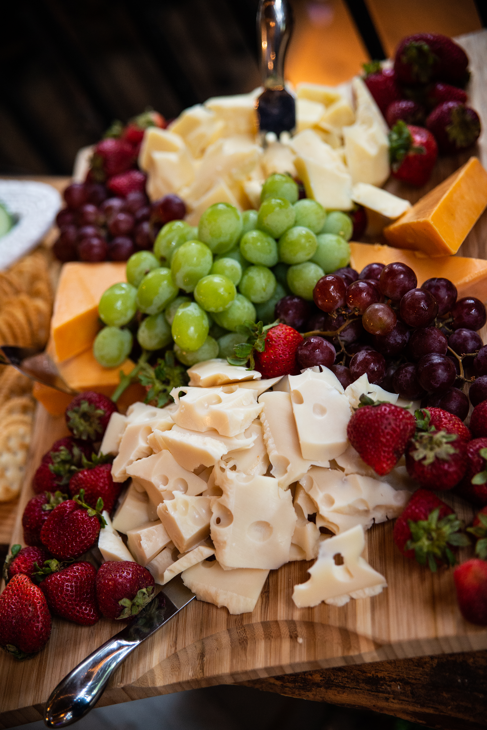 Luncheon cheeseboard with swiss and aged cheddar, gourmet crackers, fresh grapes and strawberries.