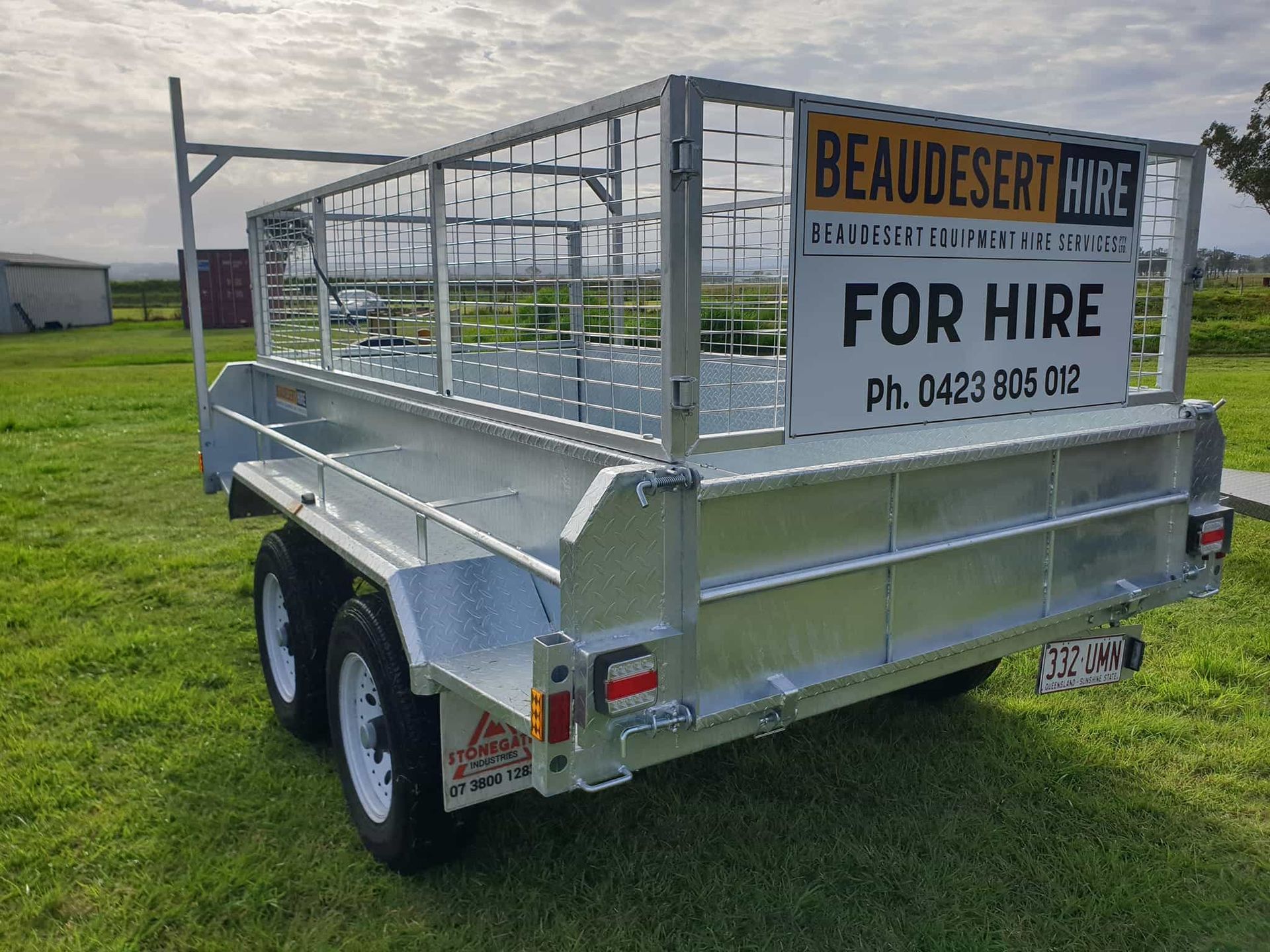 A trailer for hire is parked in a grassy field. — Beaudesert Equipment Hire Services in Beaudesert, QLD