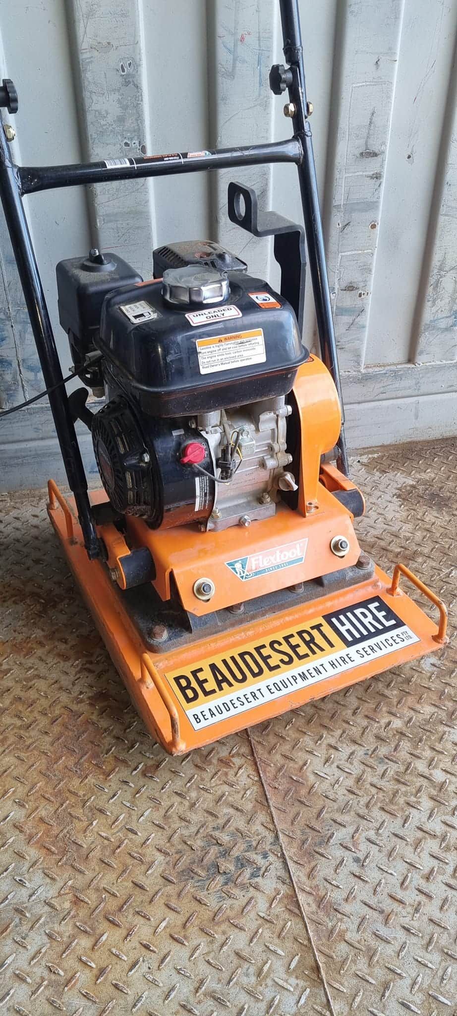 A small orange and black machine is sitting on a tiled floor. — Beaudesert Equipment Hire Services in Beaudesert, QLD