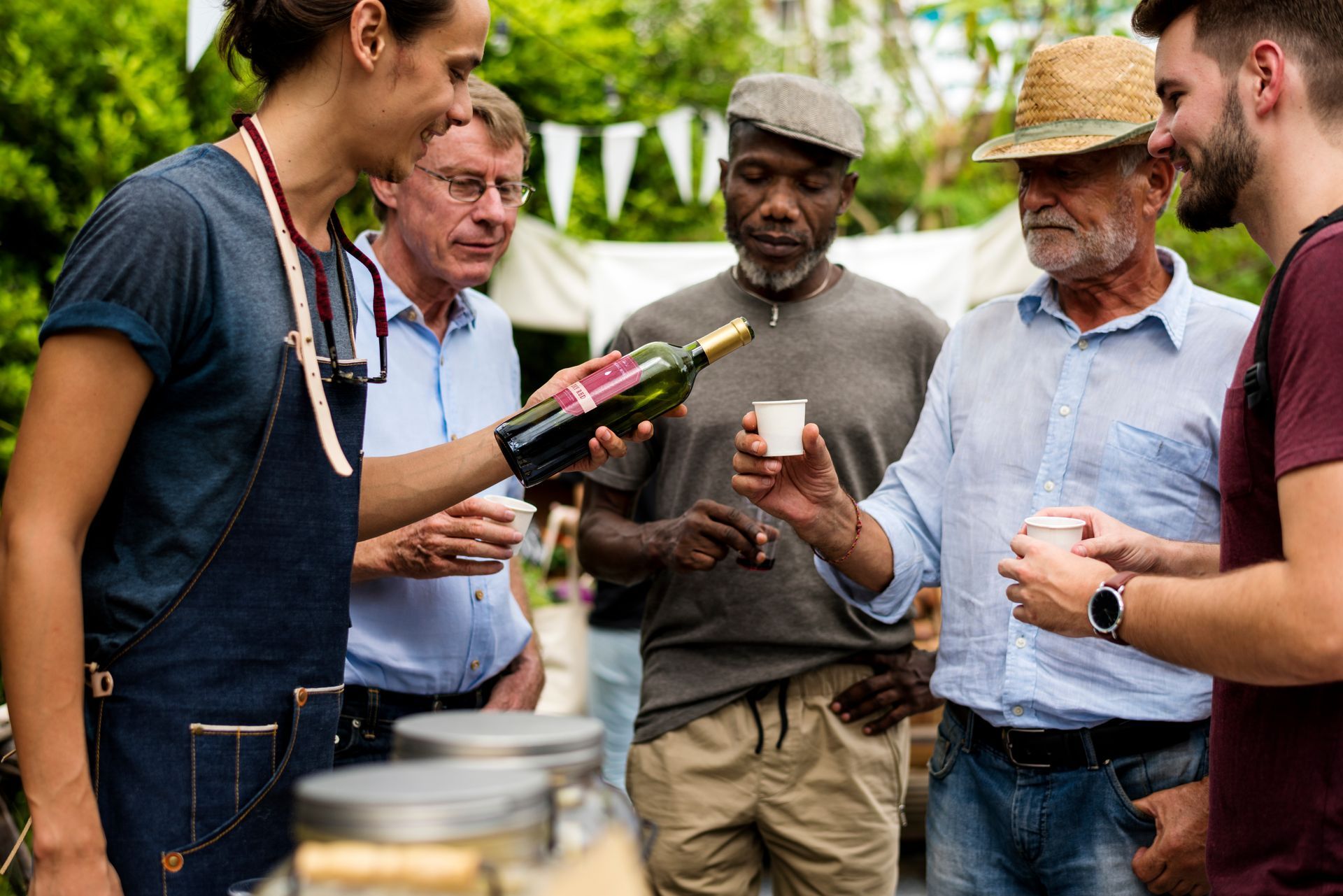 Two people are toasting with wine glasses in a vineyard.