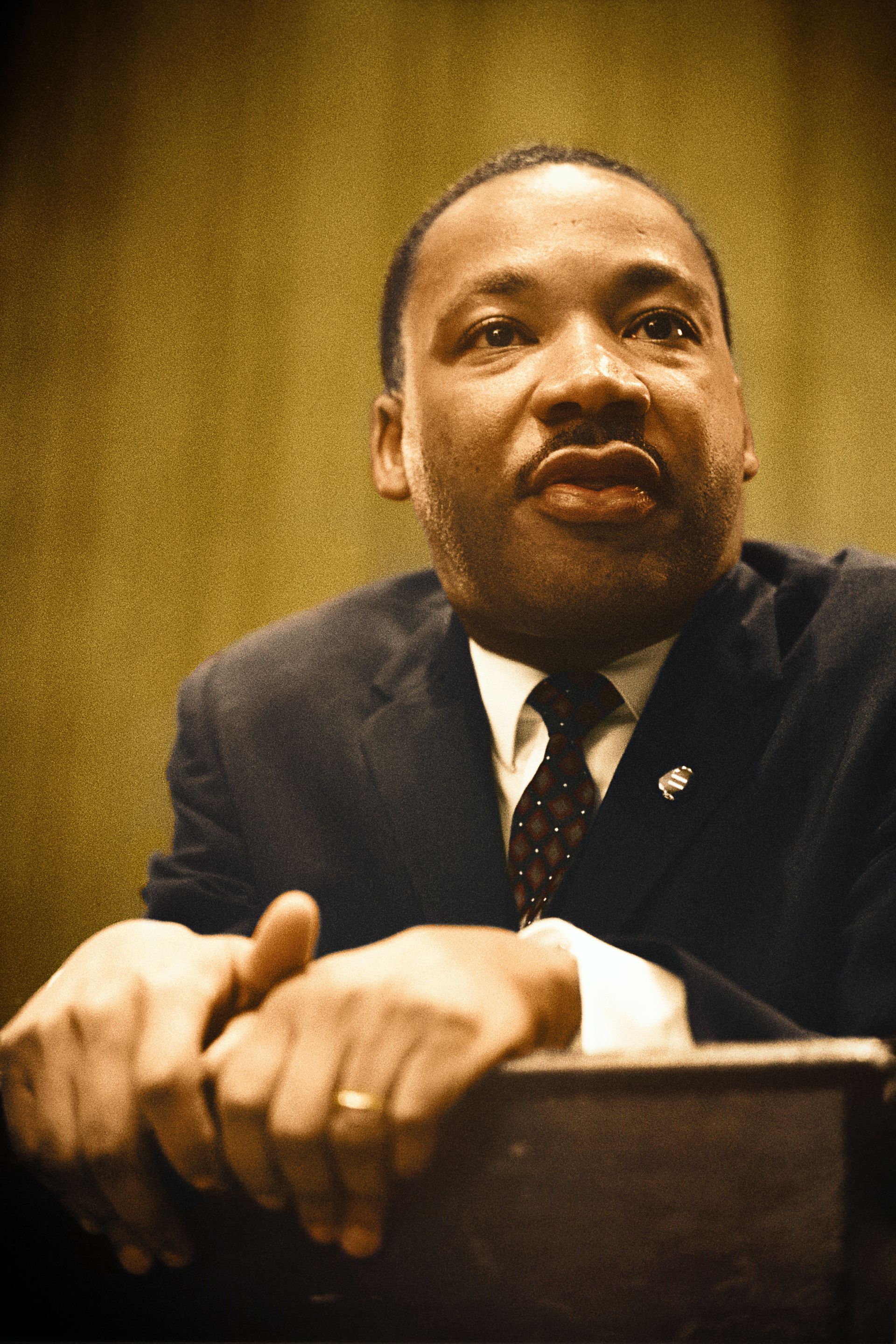 A man in a suit and tie is giving a speech