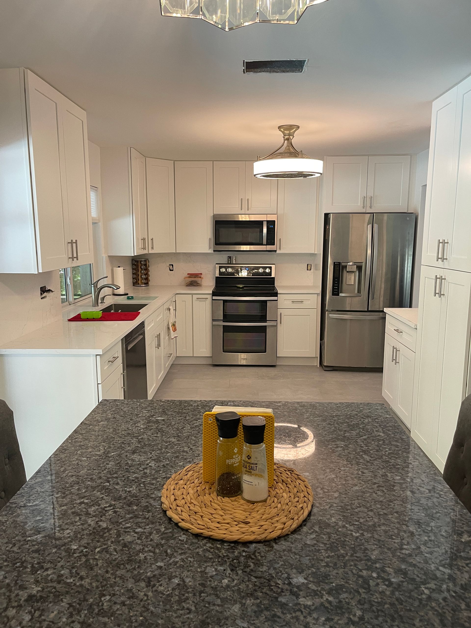 A kitchen with white cabinets and stainless steel appliances