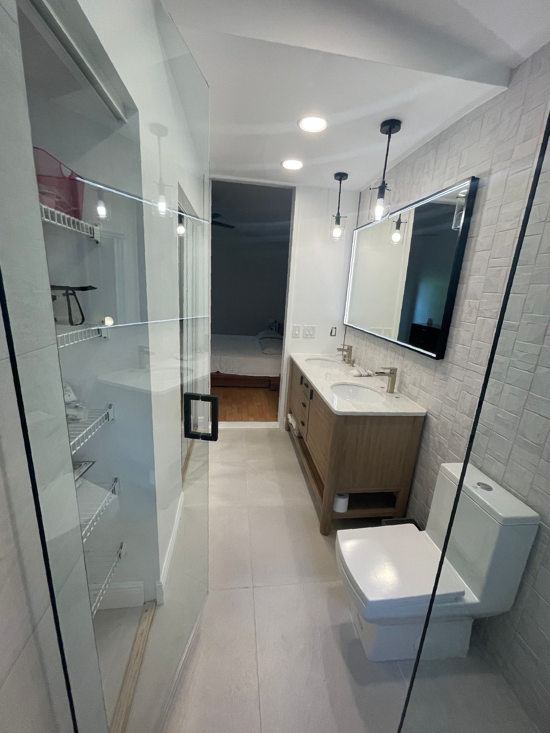 A bathroom with a toilet , sink , mirror and walk in shower.