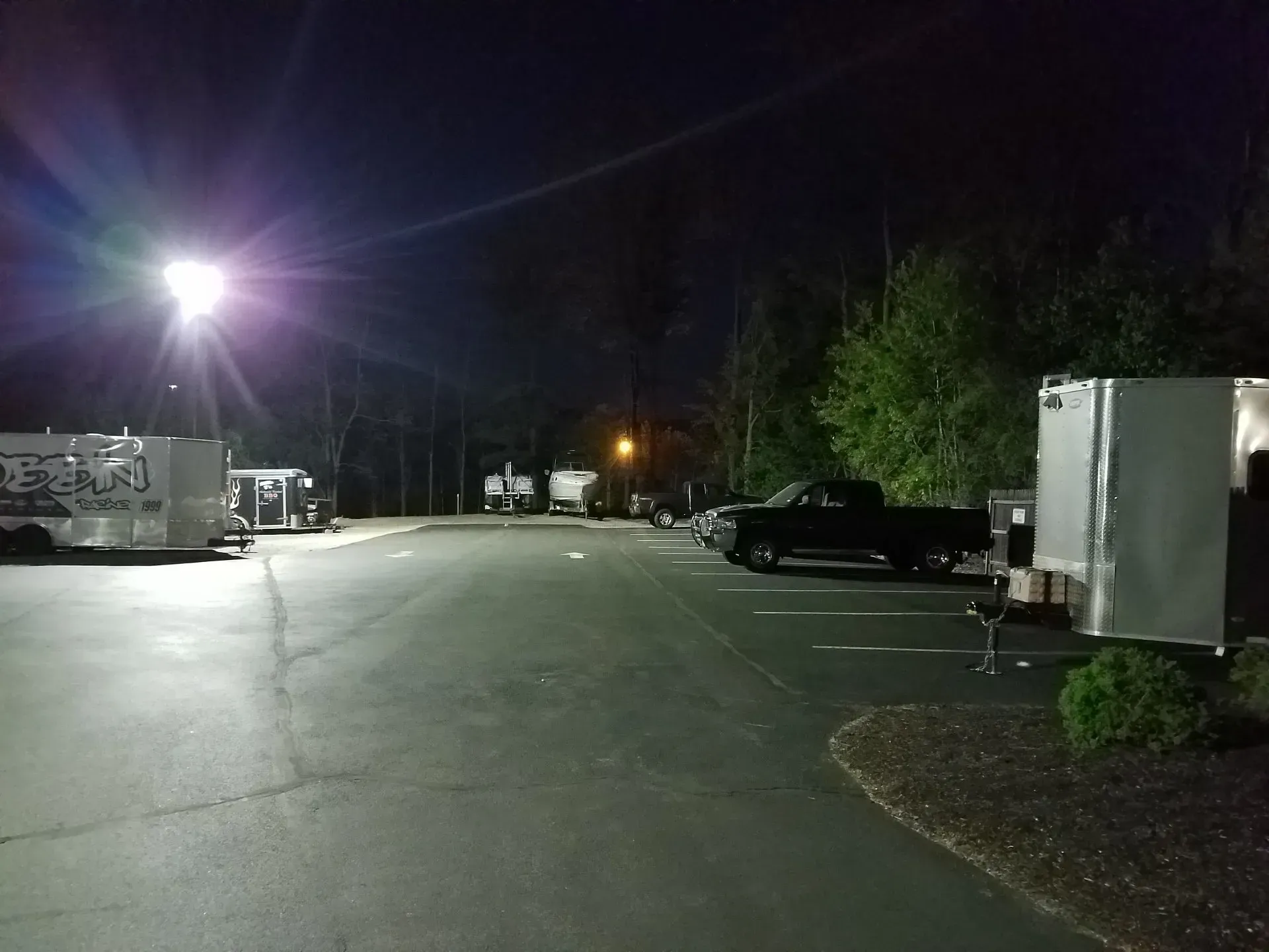 A truck is parked in a parking lot at night.