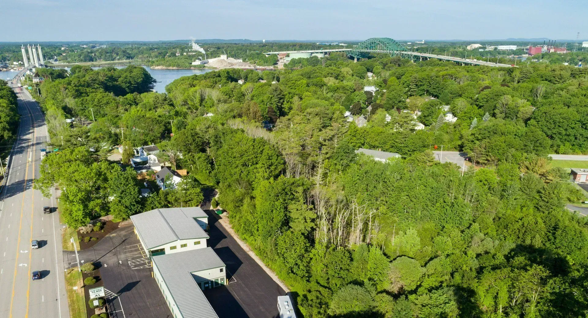 An aerial view of a motel surrounded by trees and a road.
