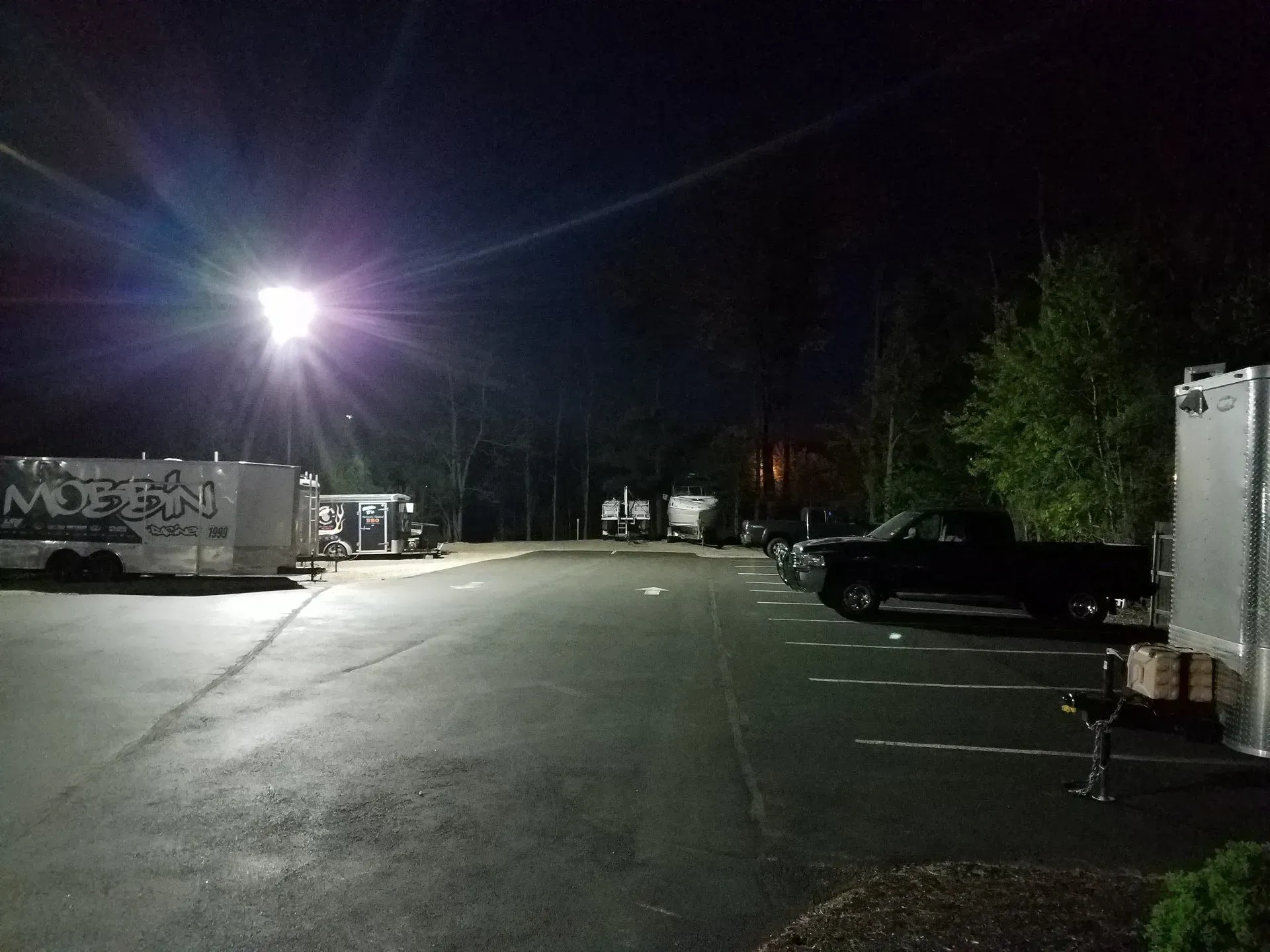 A truck is parked in a parking lot at night.