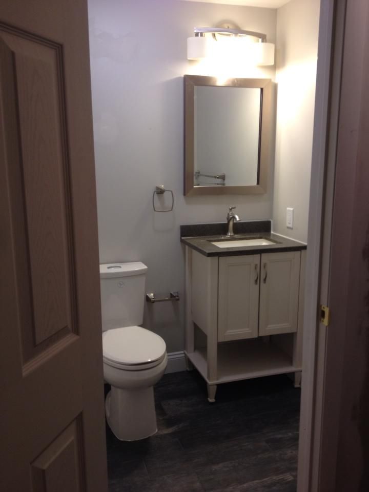 A bathroom with a toilet a sink and a mirror