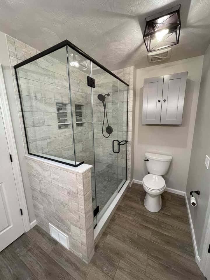 A bathroom with a walk in shower and a toilet.