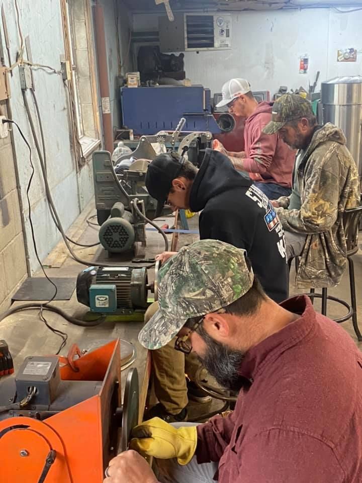 A group of men are working on a machine in a workshop.