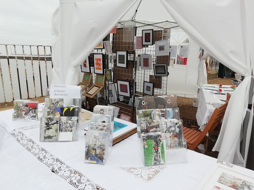 The inside of the stall with multiple frames for sale as well as Miriam King's postcards