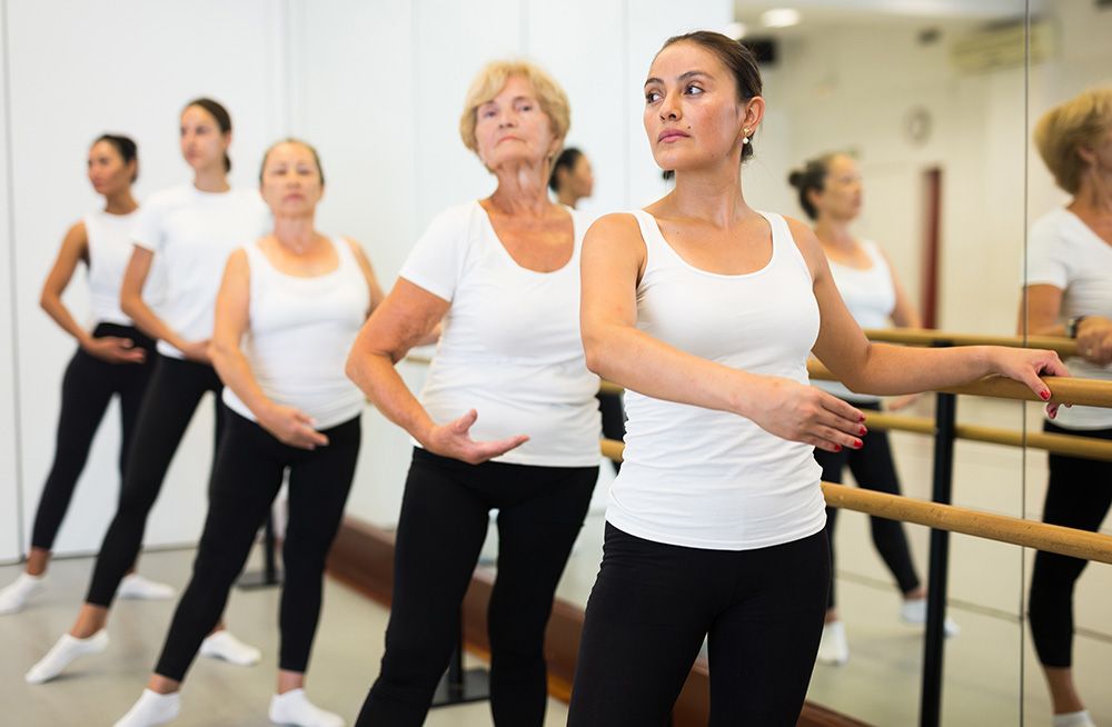 A group of elderly people are lifting dumbbells in a gym.