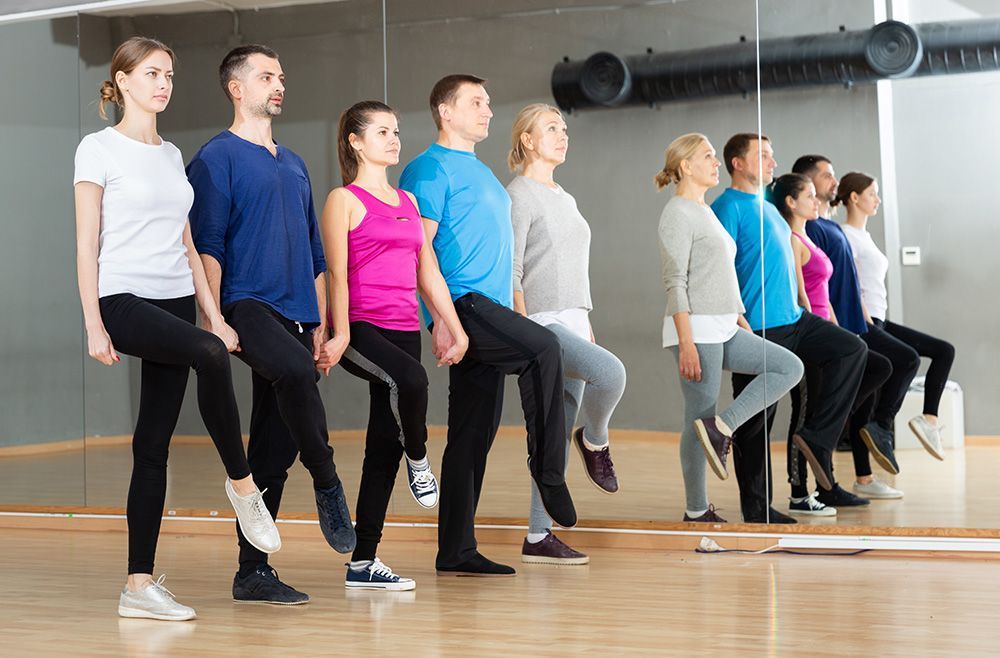 A group of elderly people are lifting dumbbells in a gym.