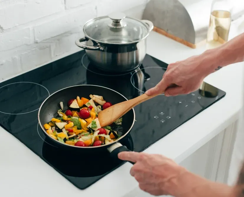 A Carer Cooking a Meal on a Stovetop — Ani's Care Pty Ltd In Millner, NT