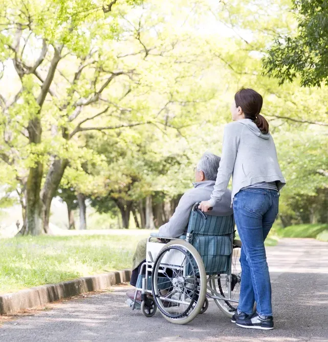 A Caregiver Taking a Man Out For A Walk in a Park— Ani's Care Pty Ltd In Millner, NT