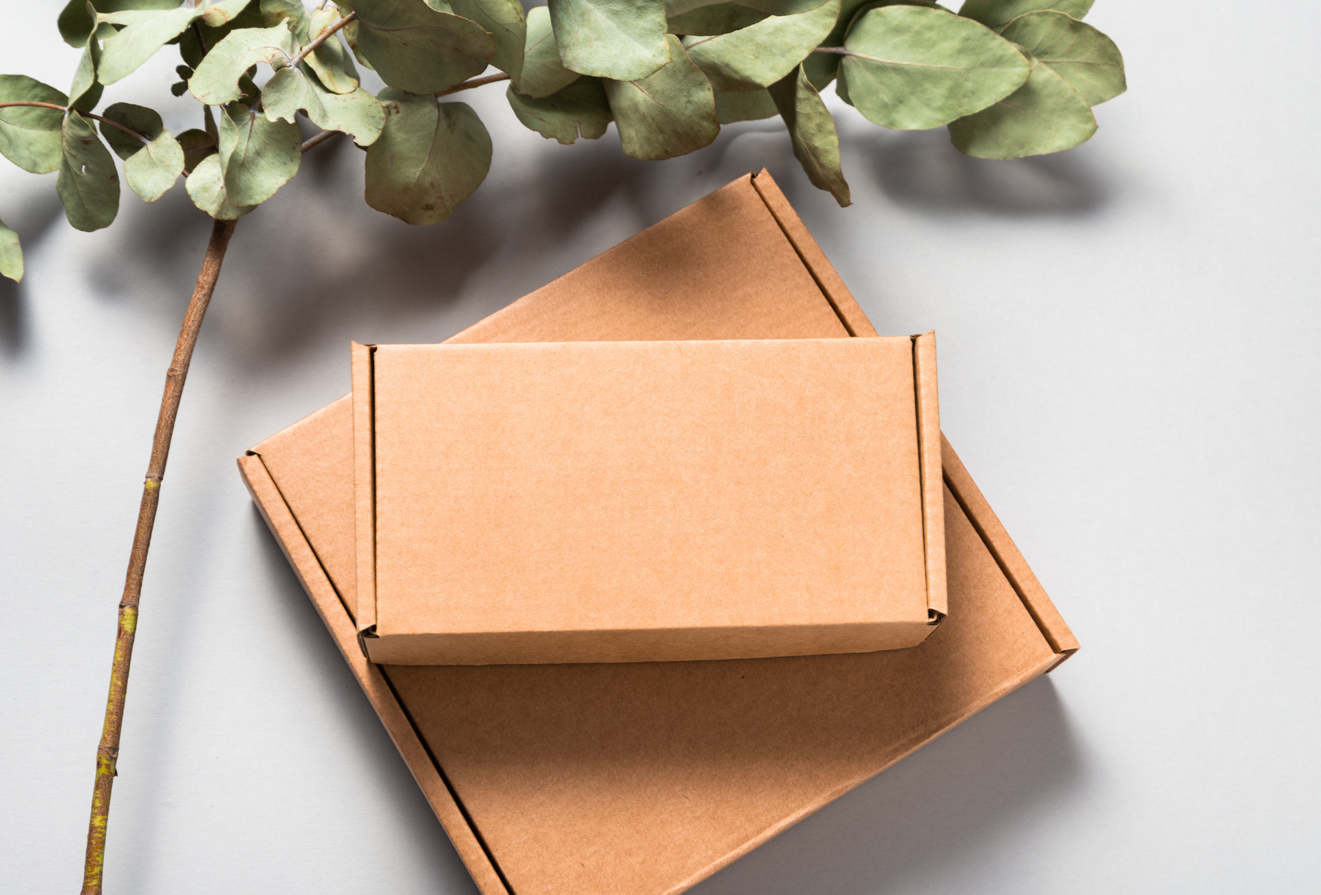 Two cardboard boxes are stacked on top of each other on a table.
