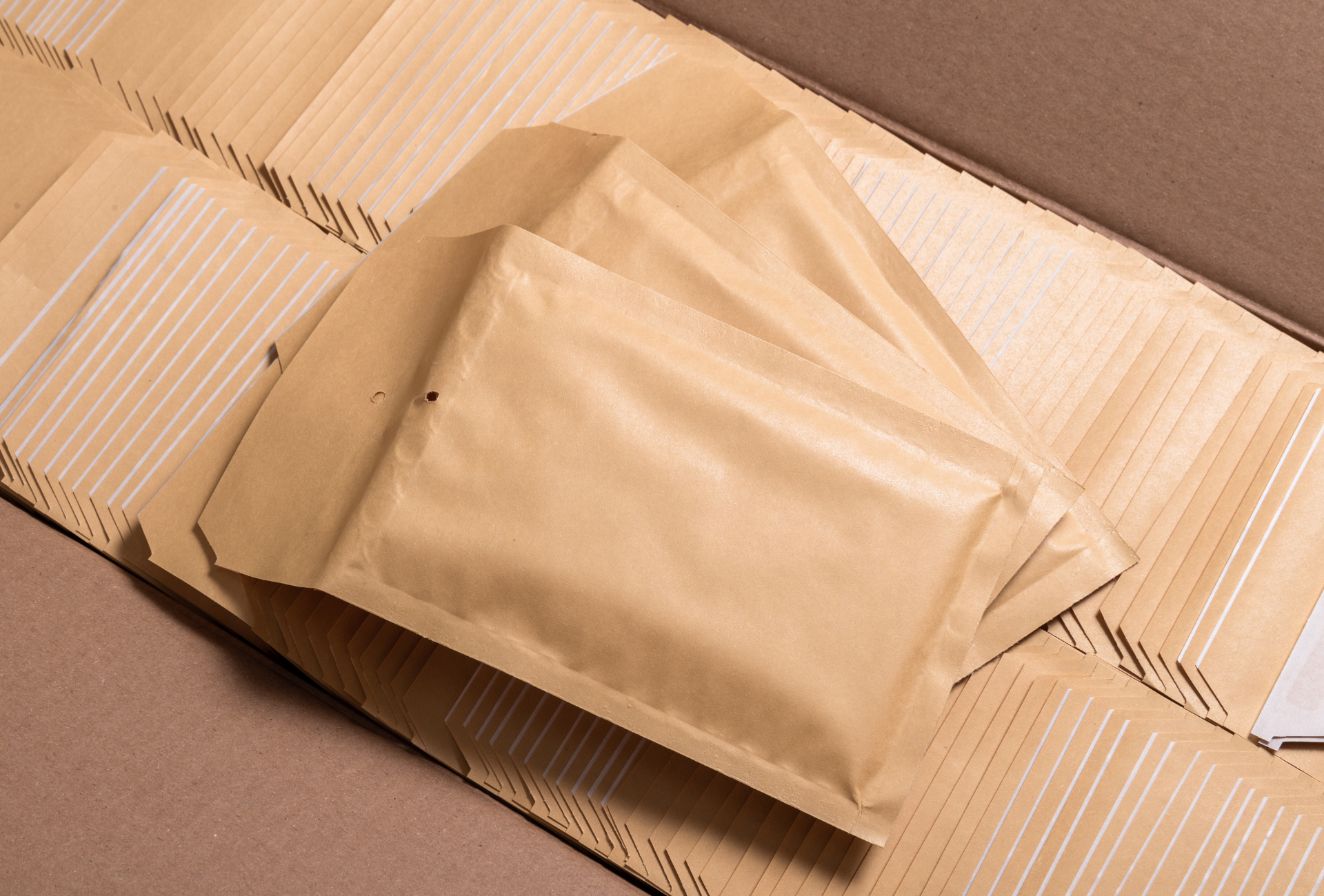 A stack of brown envelopes sitting on top of a cardboard box.